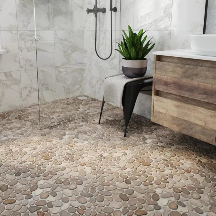 a bathroom with a toilet, sink and shower in it's center area that has pebbles on the floor