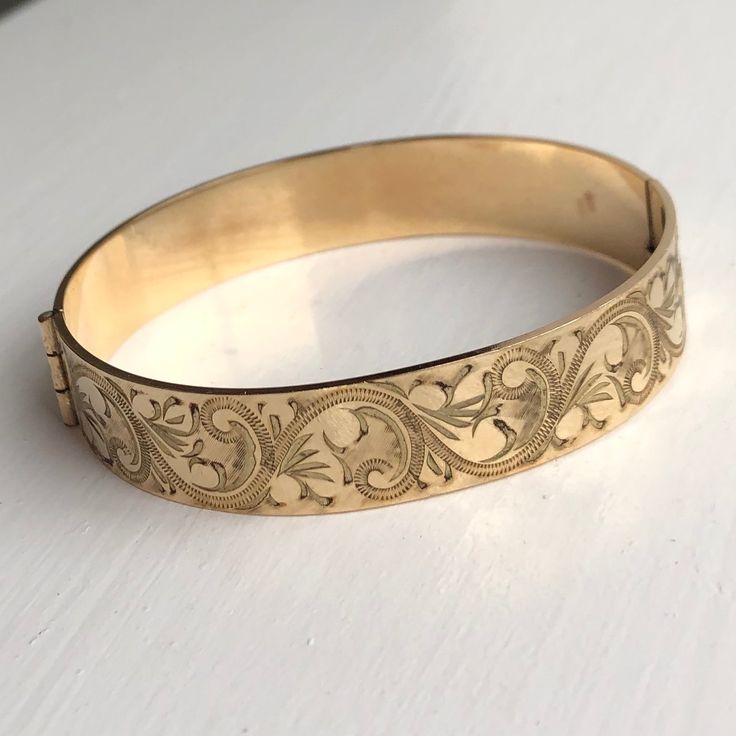 A Vintage bangle displaying beautiful engravings. The wonderful warm yellow gold colour really shows off the detailing perfectly. CONDITION: Great condition. Wear consistent with age and use. Please see photos for more detail. Strong clasp.  BAND WIDTH: 12mm APPROX. INTERNAL MEASUREMENT (AROUND): 180mm DIAMETER (INTERNAL): 53mm x 60mm WEIGHT: 24.1 grams ) Engraved Bangle Bracelet, Engraved Bangle, Vintage Bangles, Warm Yellow, Gold Engraving, Gold Colour, Perfect Ring, Pearl Ring, Bangle Bracelet