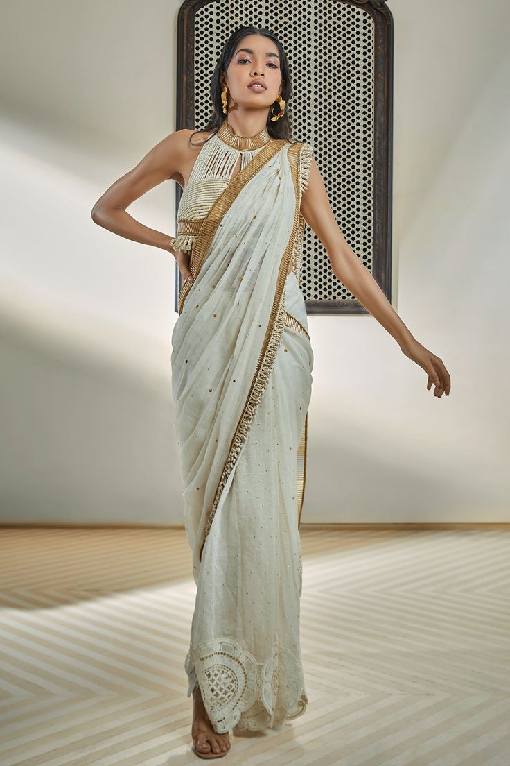 Ivory pre-draped saree with mild badla embroidery, contrast pipe and rope hand embroidered border
Components: 1
Pattern: Embellished, Hand Embroidery
Type Of Work: Rope, Pipe
Fabric: Chanderi
Color: Ivory
Other Details: 
Crochet flower embroidered hemline
Note: Blouse and belt worn by the model is not for sale
Occasion: Sangeet,Cocktail - Aza Fashions Transitional Festive Pre-draped Saree With Embroidered Border, Elegant Cotton Silk Pre-draped Saree With Embroidered Border, Traditional White Pre-draped Saree With Embroidered Border, Transitional Dola Silk Pre-draped Saree For Reception, Designer Bollywood Pre-draped Saree In Off White, Festive Off White Pre-draped Saree With Traditional Drape, Elegant Choli With Embroidered Border For Reception, Embroidered Chanderi Pre-draped Saree For Reception, Festive Dola Silk Pre-draped Saree With Embroidered Border