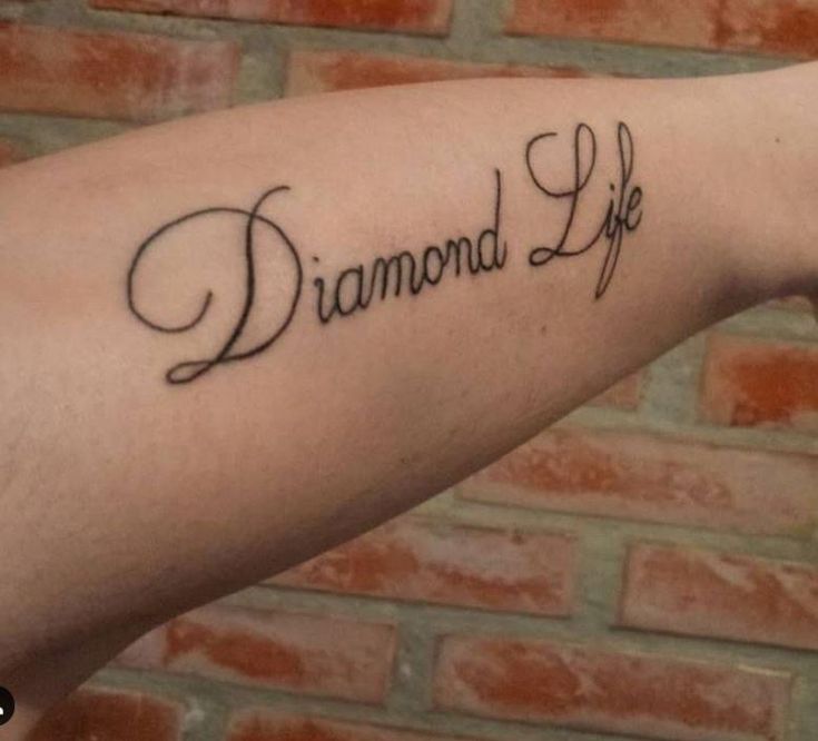 a woman's arm with the words diamond life written on it, in cursive font