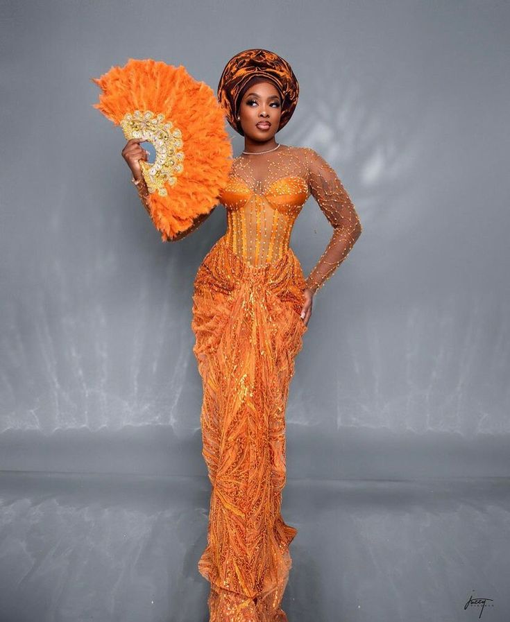 Become a showstopper in this stunning number!  Hand fan and head gear (gele) sold differently.  Please note that custom/luxury dresses cannot be returned or exchanged. All sales are final! ‼️MEASUREMENTS REQUIRED ‼️ Burst Hips  Waist Dress length  Sleeve length  Under burst Shoulder  Please note that the exact fabric might not be available and we will provide similar options  Made with 100% lace Care: Hand wash. Do not bleach Feel free to start a chat for any enquiry. Thanks for visiting. Luxury Red Sets For Traditional Ceremonies, Traditional Laos Wedding Dress, Yellow Ball Gown For Wedding, Fitted Orange Evening Dress For Wedding, Yellow Floor-length Evening Dress For Wedding, Orange Floor-length Evening Dress For Wedding, Orange Fitted Wedding Gown, Fitted Orange Wedding Gown, Traditional Orange Wedding Dress