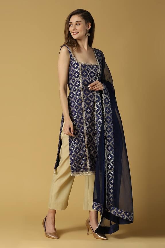 Deep blue kurta with floral woven pattern and lace detailing. Paired with pant and floral dupatta.
Components: 3
Pattern: Woven
Type Of Work: Floral
Neckline: Square
Sleeve Type: Sleeveless
Fabric: Silk and Brocade Blend
Color: Blue, Gold
Other Details: 
Side slits
Tassel detailing
Attached lining
Note: The bag held by the model is not for sale
Occasion: Puja - Aza Fashions Floral Dupatta, Blue Kurta, Kurta Set For Women, Floral Squares, Straight Kurta, Fashion App, Kurta Set, Blue Silk, Set For Women