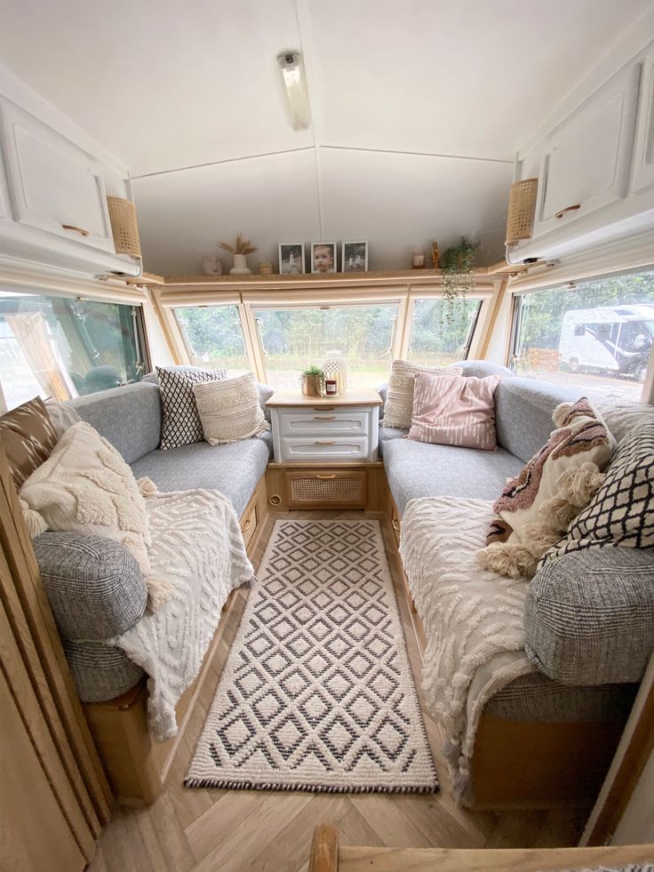 the inside of a camper with couches, rugs and other items in it