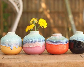 four vases with flowers in them sitting on a table