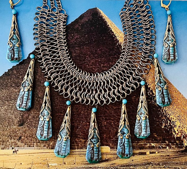 "These turquoise pressed glass Pharaohs were originally used by the Whiting Davis company in the 1950s. I have wrapped them in antique gold toned filigree, and used a vintage chain bib necklace which is adjustable in length. Earrings can be converted to posts, or clip ons, just ask ! My work has been sold at the Field Museum in Chicago during their Tut exhibit.                                                                             CONDITION - repurposed vintage & antique components have patina, and charm MEASUREMENTS - Necklace is 17.5\" - 20\" long, drops are 2\" long FABRIC/MATERIAL (s) :  Brass, Czech glass, vintage stones and chains                                           1950s Whiting Davis pressed glass Pharaohs                                           Most of my components a Assemblage Earrings, Chicago Museums, Field Museum, Vintage Chain, Daisy Necklace, Egyptian Revival, Repurposed Vintage, Earrings Turquoise, Fringe Necklace