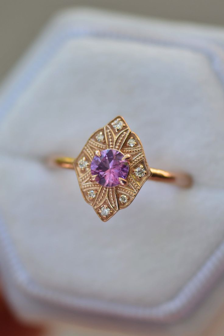 a close up of a ring in a box with an amethorate stone