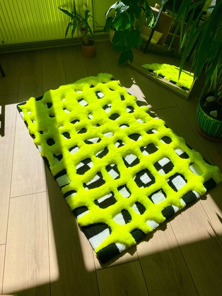 a bright yellow area rug is on the floor next to a potted houseplant