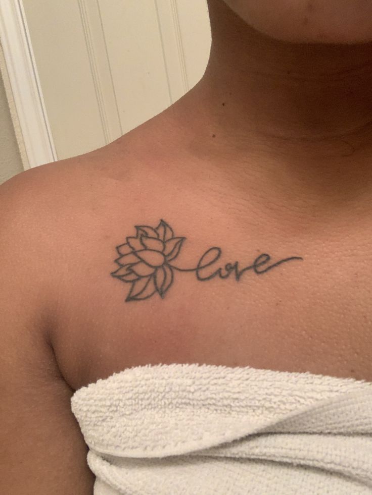 a woman with a tattoo on her chest that says love in cursive writing