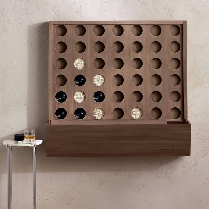 a wall mounted wine rack with several bottles in it and a small table next to it