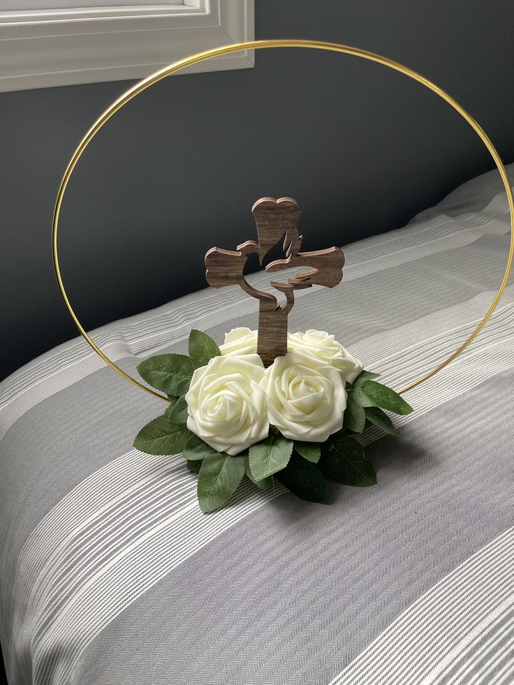 a flower arrangement in the shape of a cross on top of a bed