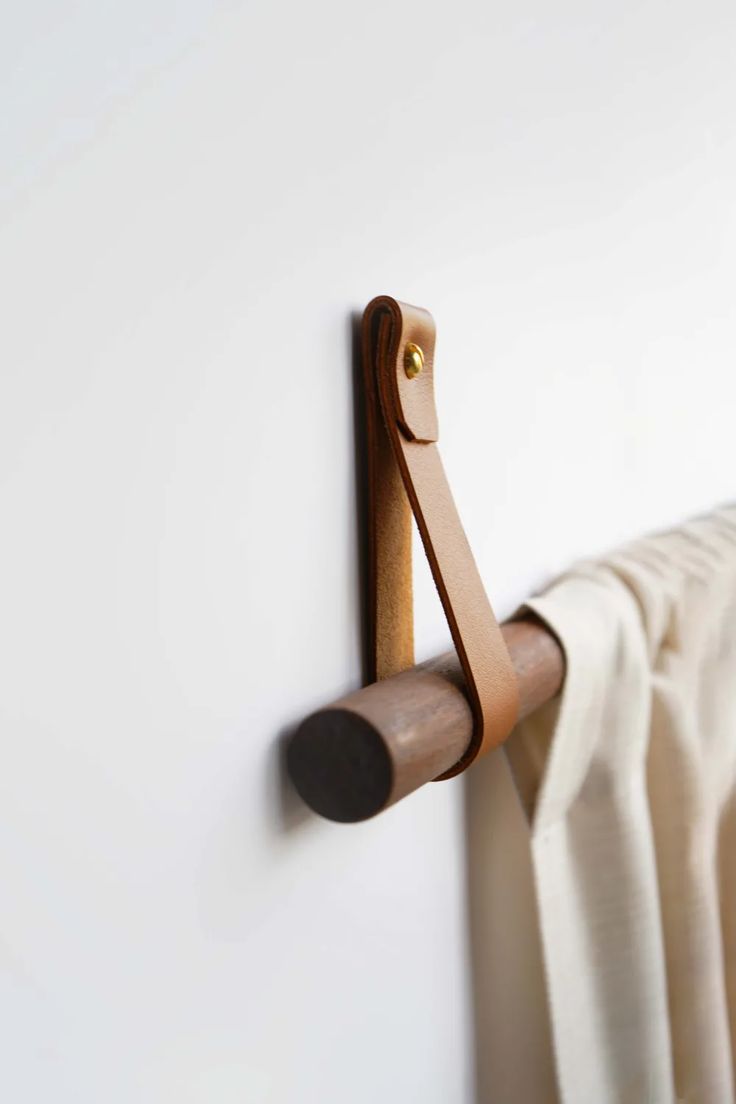 a close up of a towel rack on a wall with a curtain in the background