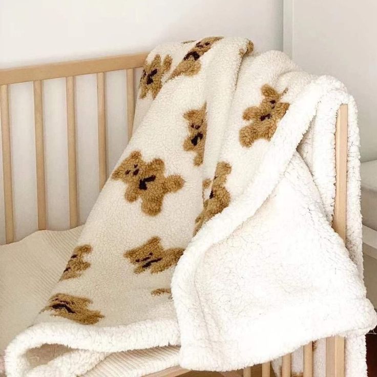 a teddy bear blanket on top of a crib