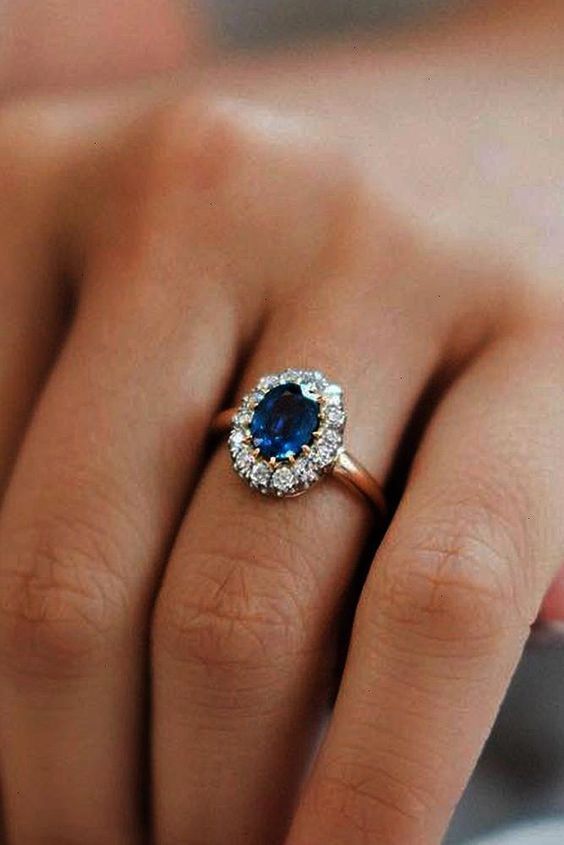 a woman's hand with a blue and white diamond ring