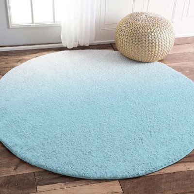 a blue and white rug on the floor next to a window