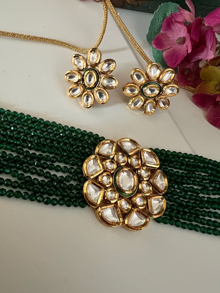 Discover the epitome of elegance with our premium necklace set. Crafted with precision and designed to turn heads, this set is a true masterpiece. Product Details: Material: Each piece is meticulously handcrafted from high-quality brass, Copper, Silver, Kundan Work, Green Beads, Premium Dori. Choker Necklace Dimensions: Weight: 55 grams. Closure Type: Premium Dori Adjustable Size: Yes Width of Choker: 4 cm.  Stud Earring Dimensions (Per Pair): Weight: 16 grams Diameter: 2.8 cm Closure Type: Push Back Closure Exquisite Design: This set boasts a design that's truly captivating, ensuring you stand out on any occasion. Compliment Magnet: Expect a shower of compliments every time you wear this stunning ensemble. Indulge in the finest craftsmanship with our necklace set. Elevate your style, make Elegant Brass Kundan Necklace For Celebration, Elegant Kundan Necklace For Celebration, Elegant Hand Set Brass Jewelry, Elegant Brass Jewelry Sets For Celebration, Elegant Hand-set Brass Jewelry, Elegant Gold Kundan Necklace Made Of Brass, Elegant Kundan Necklace With Brass For Party, Elegant Gold Kundan Necklace In Brass, Elegant Brass Kundan Necklace For Party