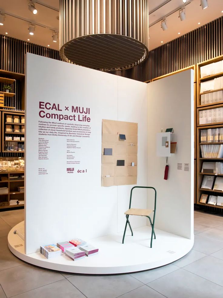 an exhibit in the middle of a room with many books on shelves and a chair next to it