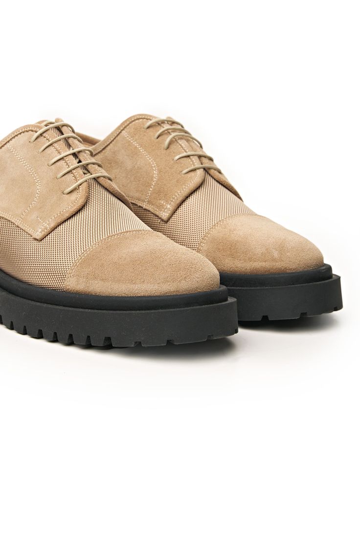 Combining modern style with unbeatable comfort, these shoes are crafted from premium suede leather, showcasing a perfect balance of durability and elegance. The fabric upper adds a contemporary touch to the classic derbies design. What sets these shoes apart are their standout features: a high, lightweight rubber commando sole for traction and bold style. Inside, enjoy the plush comfort of soft calf leather lining and insole. These shoes blend style, durability, and luxury, making them essential Suede Brogue Derby Lace-up Shoes, Suede Wingtip Oxfords For Office, Wingtip Suede Oxfords For Office, Spring Suede Lace-up Shoes With Textured Sole, Office Suede Wingtip Oxfords, Suede Wingtip Dress Shoes For Office, Suede Loafers With Contrast Sole For Workwear, Beige Oxfords With Rubber Sole For Work, Suede Lace-up Shoes With Rubber Sole For Work