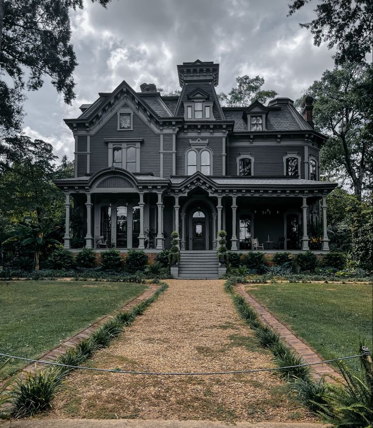 an old house with many windows and lots of grass