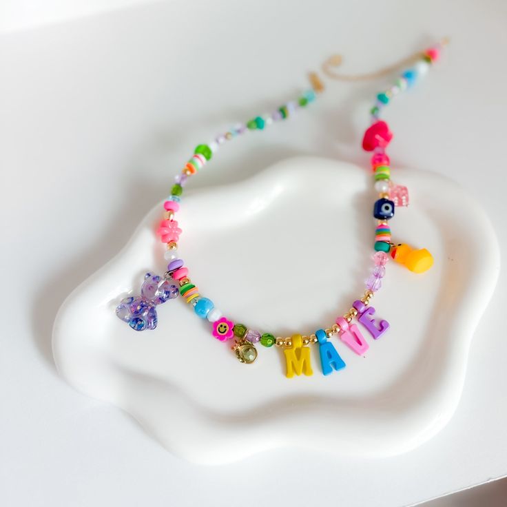 a white plate topped with a colorful beaded necklace