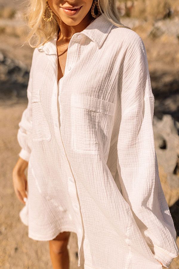 Perfect for wearing as a dress, over your fave swimsuit, or tucked into some cute shorts, our versatile white 'Standing On The Pier' top featuring lightweight and comfortable material, a button up front with a collared neckline, long loose sleeves, two accent chest pockets and two lower side pockets, and a relaxed silhouette that falls into a straight mid-thigh length hemline!  Measurements S variant has  a Bust of 48",  a Hip of 62",  a Length of 30",  a Sleeve Length of 17.5",  a Waist of 50". White Shirt With Button Closure For Summer, White Tops With Pockets For Beach Season, White Beach Tops With Pockets, White Tops With Pockets For Vacation, White Summer Shirt With Buttons, Solid Button-up Beach Shirt, Solid Color Button-up Beach Shirt, White Button Shirt For Summer, Beachwear Button-up Blouse For Vacation