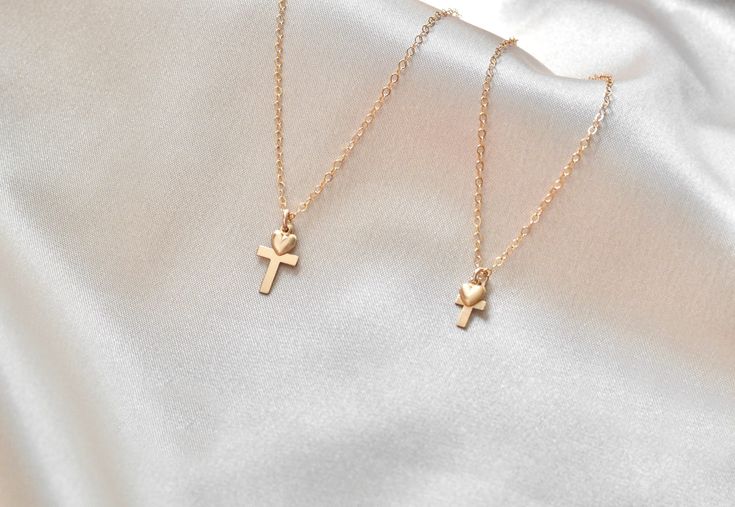 100% 14KT Gold Filled  Two size options of these beautiful,  gleaming cross + heart necklaces are available; a very dainty cross and standard sized one. Each cross is adorned with a darling puffed heart. The Cross + Heart necklace you select arrives gift ready in a corked glass vial, placed within a soft black velveteen pouch, and embossed tissue. Necklace details: + High tensile strength 1.3mm cable chain + 16mm or 8mm cross, flat charm + 4mm puffed heart, hollow back 14k Gold Filled Cross Jewelry Gift, Dainty Cross Jewelry For Mother's Day, Delicate Cross Jewelry Gift, Dainty 14k Gold Cross Necklace Gift, Dainty 14k Gold Cross Necklace As A Gift, Gift 14k Gold Filled Cross Pendant Charm Necklace, Dainty Hypoallergenic Cross Jewelry, 14k Gold Filled Cross Necklace Gift, 14k Gold Filled Cross Pendant Necklace As Gift