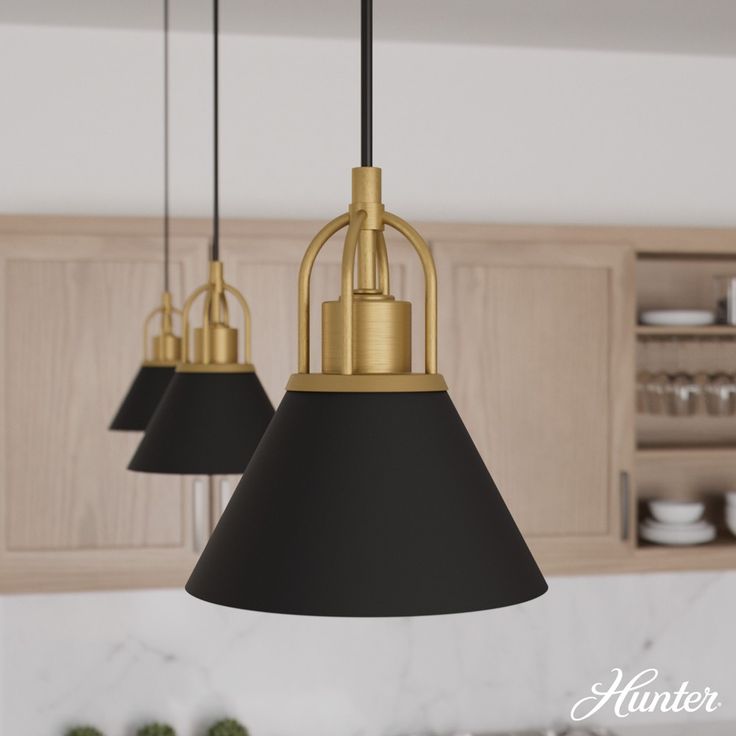 three black and gold pendant lights in a kitchen