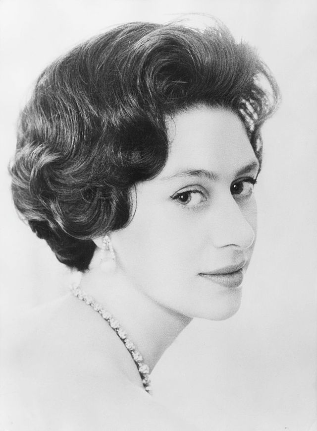 an old black and white photo of a woman with pearls on her head, wearing a tiara