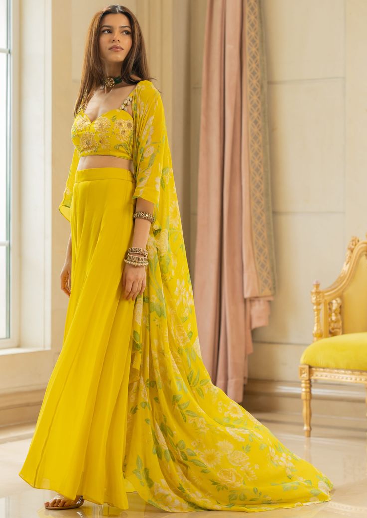 Featuring drama jacket set in our signature print consisting of a hand highlighted embroidery detailed blouse which is adorned using kowri shells and paired with jacket and pants. Yellow Georgette Sets With Printed Motifs, Designer Sets With Set-in Sleeves And Traditional Drape, Elegant Georgette Sets With Printed Motifs, Elegant Yellow Sets With Printed Motifs, Elegant Saree Set For Spring, Festive Spring Sets With Cape Sleeves, Designer Wear Sets With Cape Sleeves For Spring, Silk Sets With Set-in Sleeves For Festive Occasions, Elegant Sets With Printed Motifs For Reception