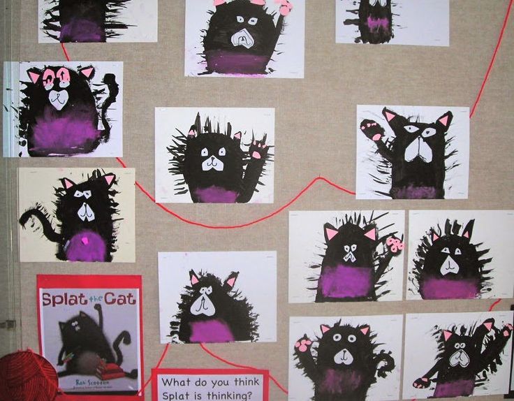 a bulletin board with pictures of black cats and purple balls of yarn on the wall