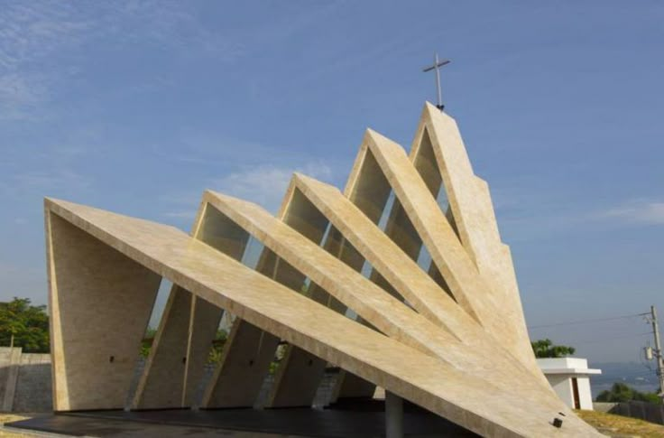 a large triangular building sitting on top of a lush green field