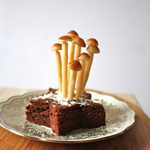 a piece of cake on a plate with mushrooms sticking out of it