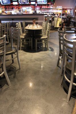 the inside of a restaurant with tables, chairs and televisions in the back ground