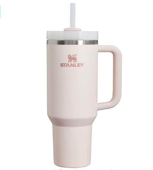 a white travel mug with a straw sticking out of it's lid and the words stanley on it