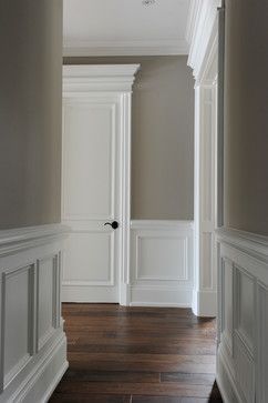 an empty hallway with wood floors and white walls