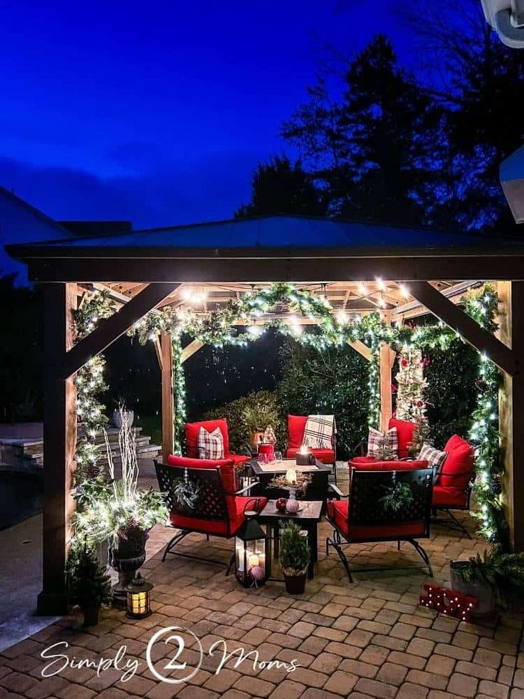 an outdoor gazebo decorated with christmas lights and greenery