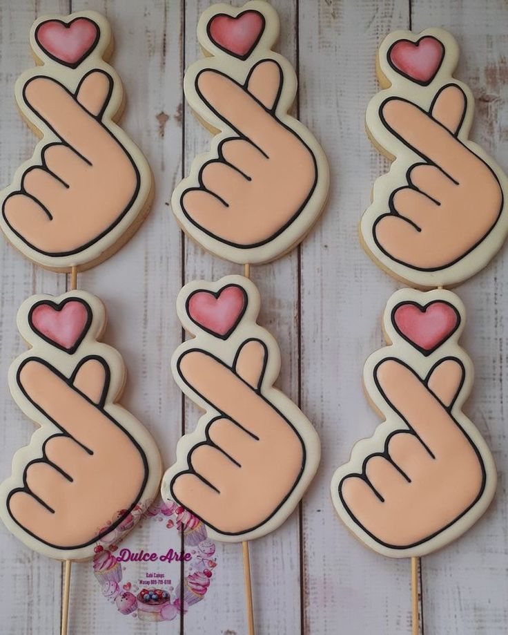 several decorated cookies with pink hearts in the shape of hands