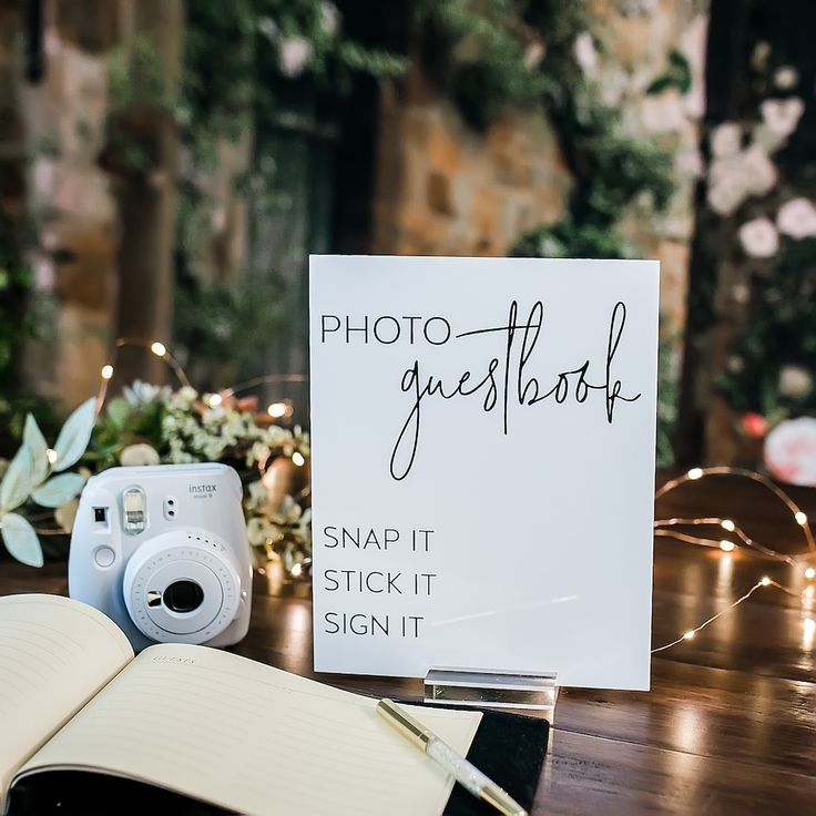 an open book sitting on top of a table next to a camera