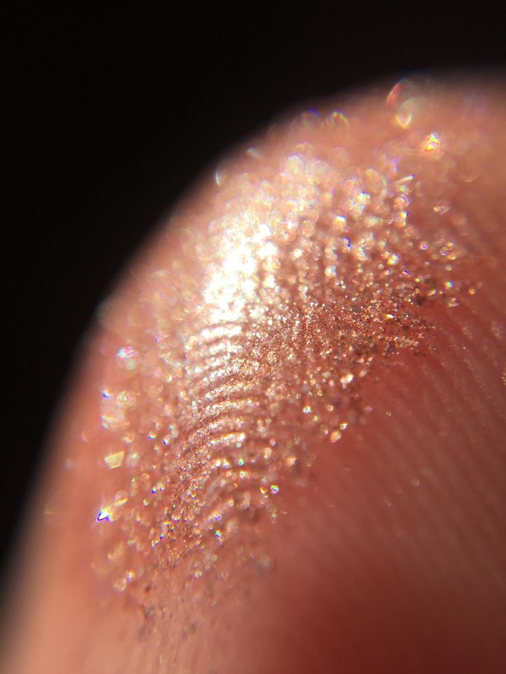 a close up view of the tip of someone's finger with glitter on it