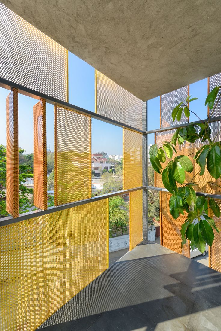 the interior of a building with large windows and yellow mesh covering it's walls