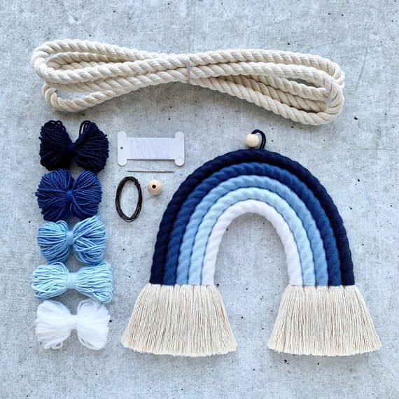 the kit is laid out on the ground with yarn, scissors and other items to make it