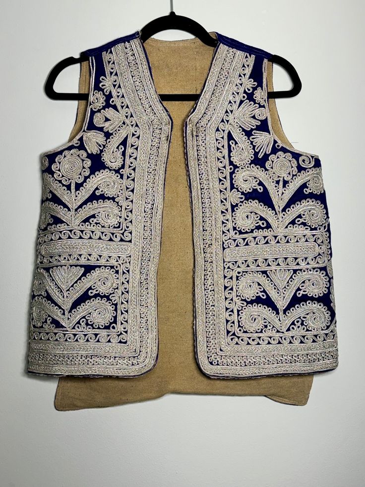 Made in Afghanistan, this a rare find vintage sleeveless waistcoat. Hand embroidery on velvet. A very antique piece in mint condition.  Measurements in inches (Flat): Shoulder: 12.5 Bust: 19 Length: 23 Note: Worn and minor signs of wear. Festive Bohemian Vest With Intricate Embroidery, Traditional Sleeveless Festive Vest, Traditional Sleeveless Vest For Festive Occasions, Festive Sleeveless Embroidered Vest, Folk Style Festive Vest With Floral Embroidery, Festive Vest With Intricate Embroidery, Festive Folk Vest With Floral Embroidery, Sleeveless Vest With Intricate Embroidery For Festivals, Festive Sleeveless Vest With Intricate Embroidery