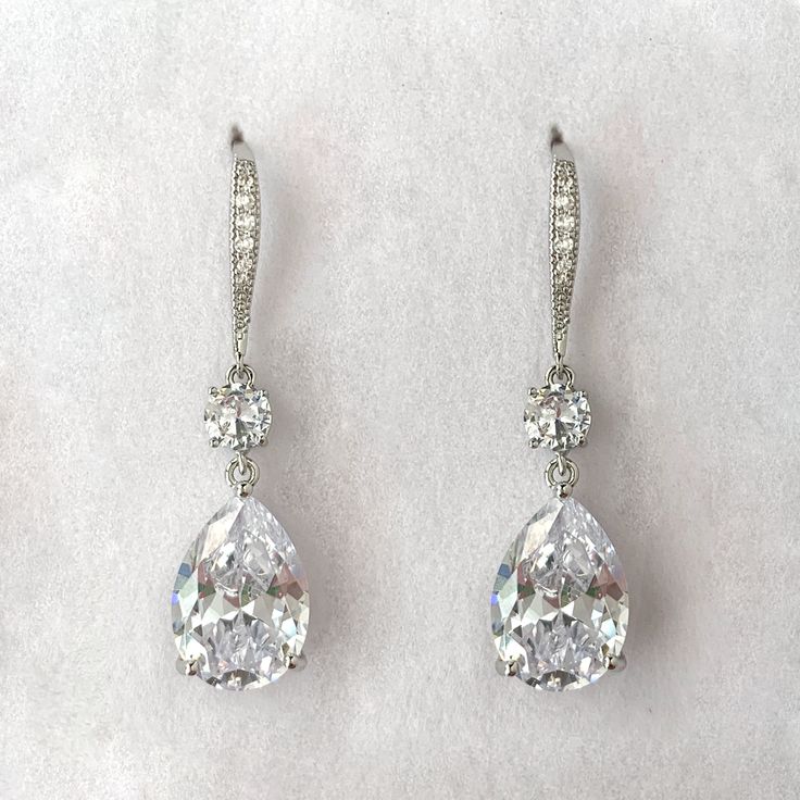 Our Iris earrings are a classic teardrop shape in a slightly longer length to perfectly frame the face. Tiny crystals are embedded into the french hook frames for additional sparkle. Length: 1 3/4", Width 1/2" Pear stones measures 14mm x 10mm 9 carat total weight Carat total weight based on diamond equivalent Custom gift box and microfiber storage pouch included Elegant Teardrop Earrings With French Hook, Teardrop Chandelier Earrings With Diamond Accents For Formal Occasions, Elegant Formal Teardrop Earrings With French Hook, Formal Teardrop Chandelier Earrings With Diamond Accents, Elegant Long Drop Teardrop Earrings With Lever Back, Classic Teardrop Earrings For Wedding, Classic Teardrop Crystal Earrings For Parties, Teardrop Crystal Diamond Earrings With Sparkling Stones, Teardrop Linear Earrings For Party