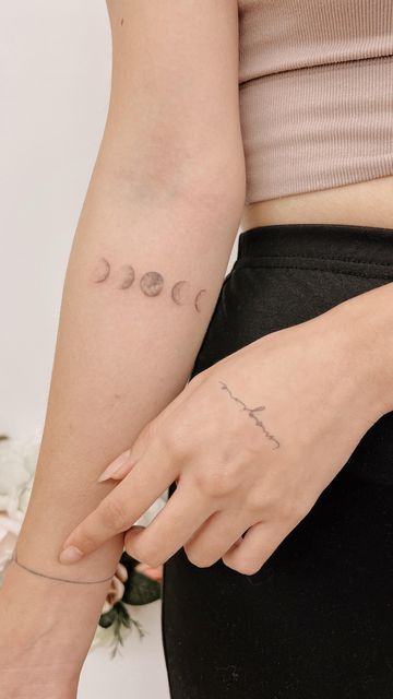 a woman's arm with three phases of the moon tattooed on it