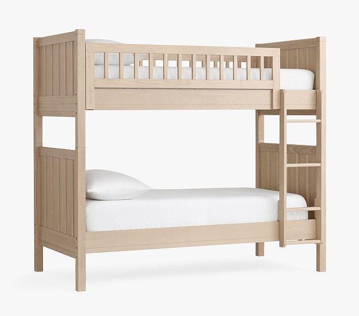 a wooden bunk bed with white sheets and pillows on top of it, against a white background