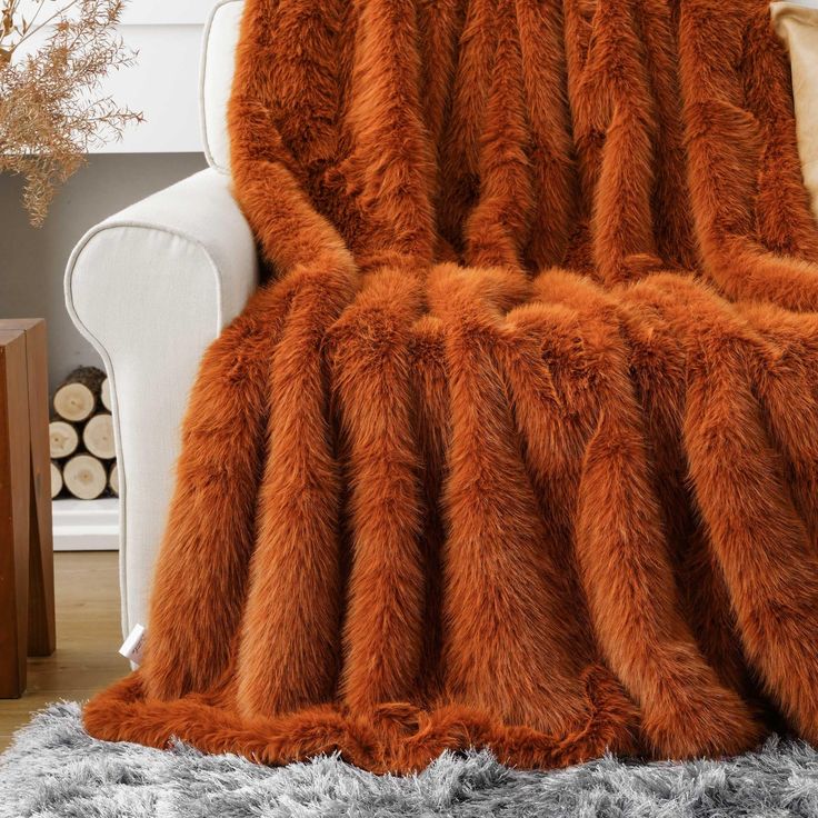 an orange furry blanket sitting on top of a white chair