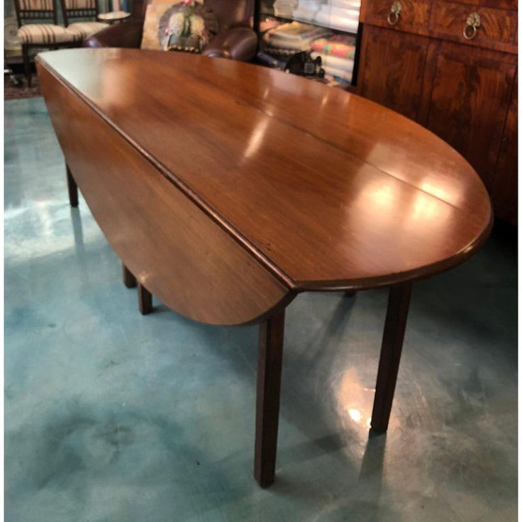 a large wooden table sitting on top of a blue floor next to a brown chair