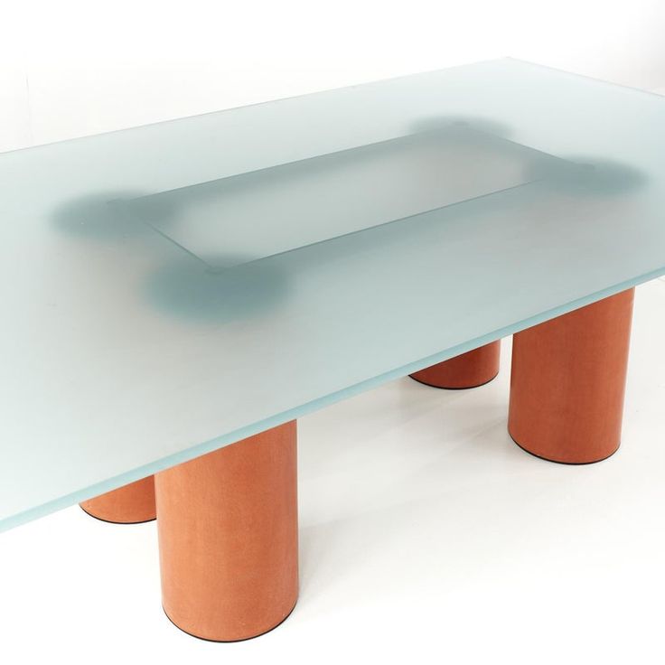 a glass table with two orange legs on it