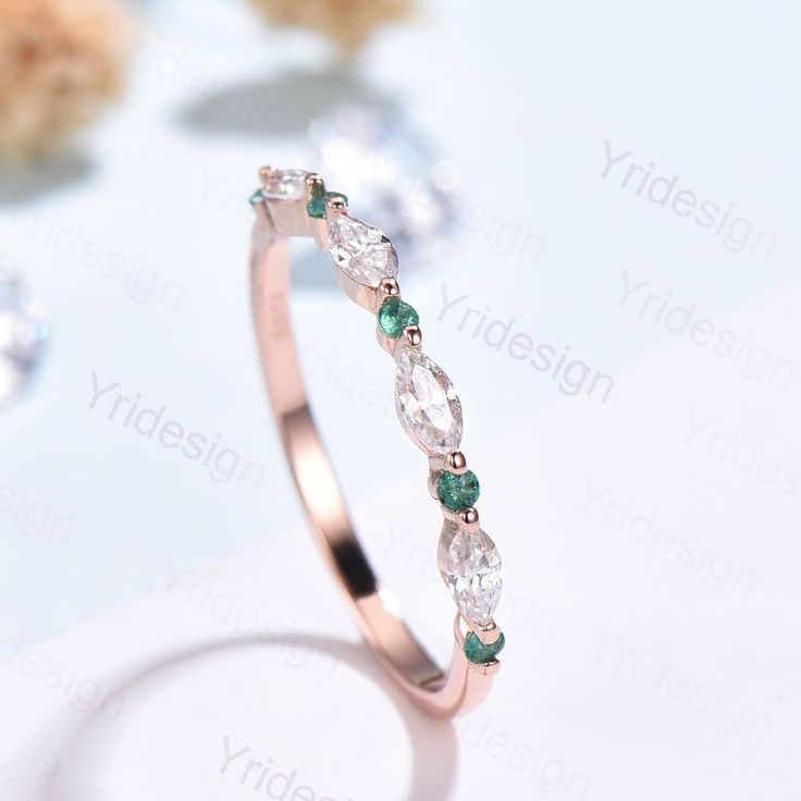 a diamond and emerald ring on a table