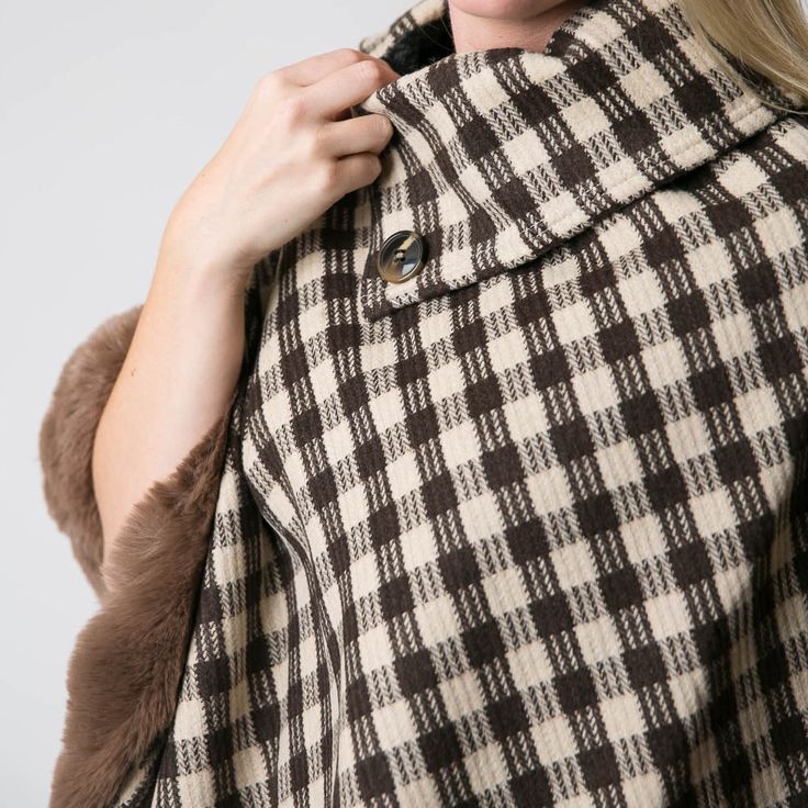 These luxurious ponchos with soft faux fur trim are the perfect addition to any cold weather wardrobe. Button detail and timeless check designs. Dress up or down. Pair with our hats and gloves for extra warmth! Details & Care One Size 28.5” L x 29” W 27” L from center point to bottom with 3” L faux fur trim (not including collar) 100% Polyester with faux fur trim Faux fur plush teddy bear lining Wash cold. Hang dry. Imported Brown Winter Cape For Cold Weather, Faux Fur Trim Cape For Cold Weather In Fall, Fall Cape With Faux Fur Trim For Cold Weather, Winter Plaid Poncho, Plaid Winter Poncho, Winter Wool Poncho For Cold Weather, Check Designs, Designs Dress, Center Point