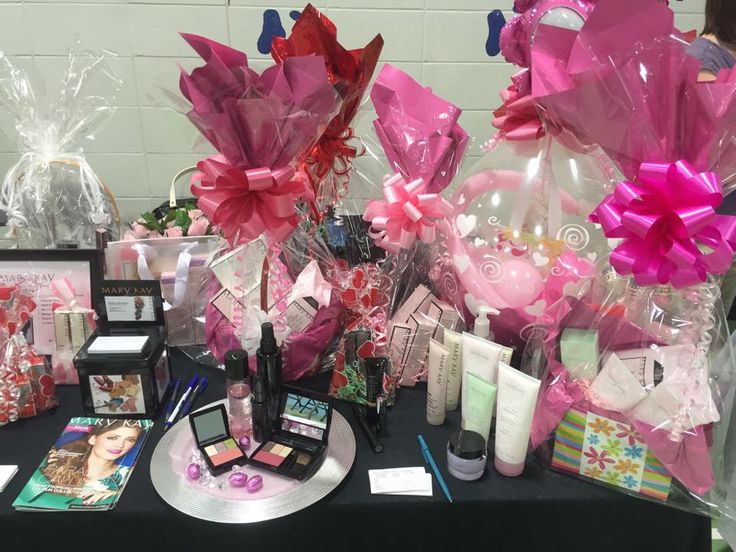 a table topped with lots of pink and white items on top of a black table